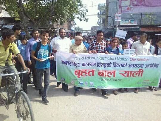 A street rally behind a banner reading “Child Labour Restricted Nation, Our Mission”.